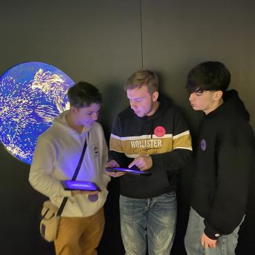 Schüler bei interaktiver Station mit Tablets beim Diskutieren