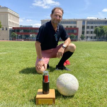 Sportlehrer mit Pokal