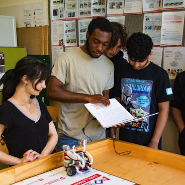 Schülerin und Schüler arbeiten am Roboter