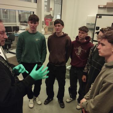 Gruppe von Schülern hören einem Professor zu