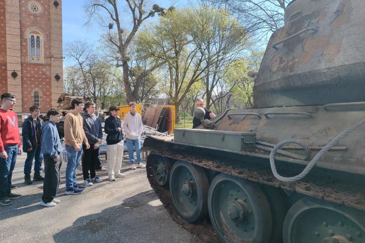 Schülerinnen und Schüler vor einem Kriegsrelikt