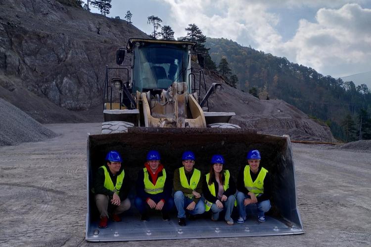 Schüler in Baggerschaufel